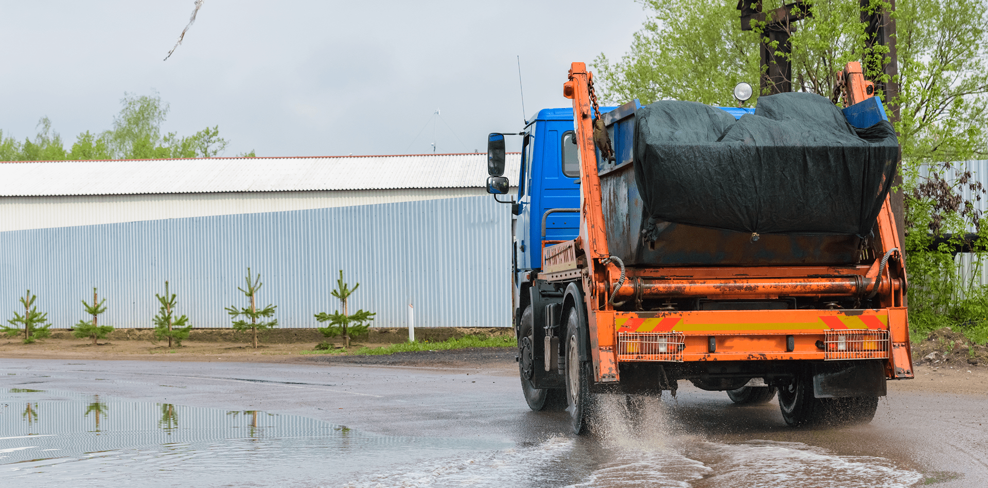 Waste hauling truck removing debris from an industrial facility.